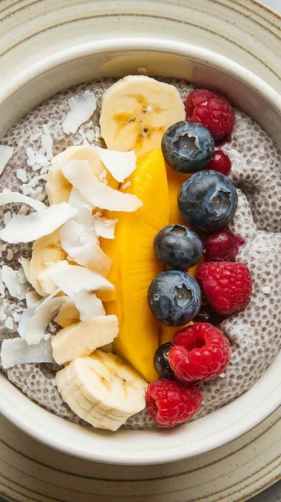 A bowl of chia seed pudding topped with fresh fruits and shredded coconut.