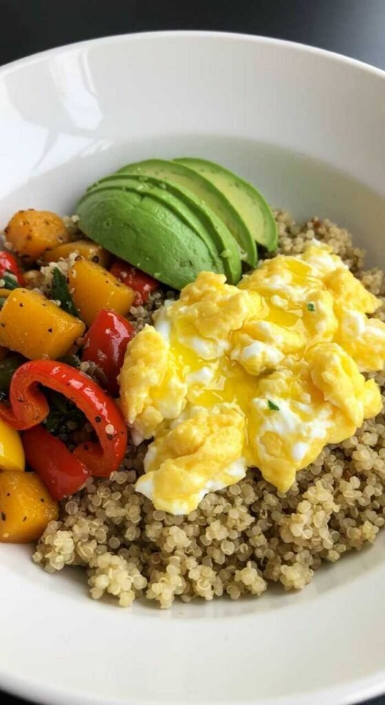 A savory quinoa breakfast bowl with eggs, vegetables, and avocado.
