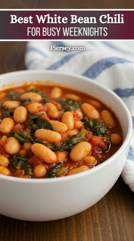 A steaming bowl of white bean chili with greens and tomatoes in a white bowl. Text reads "Best White Bean Chili for Busy Weeknights. Piersey.com".