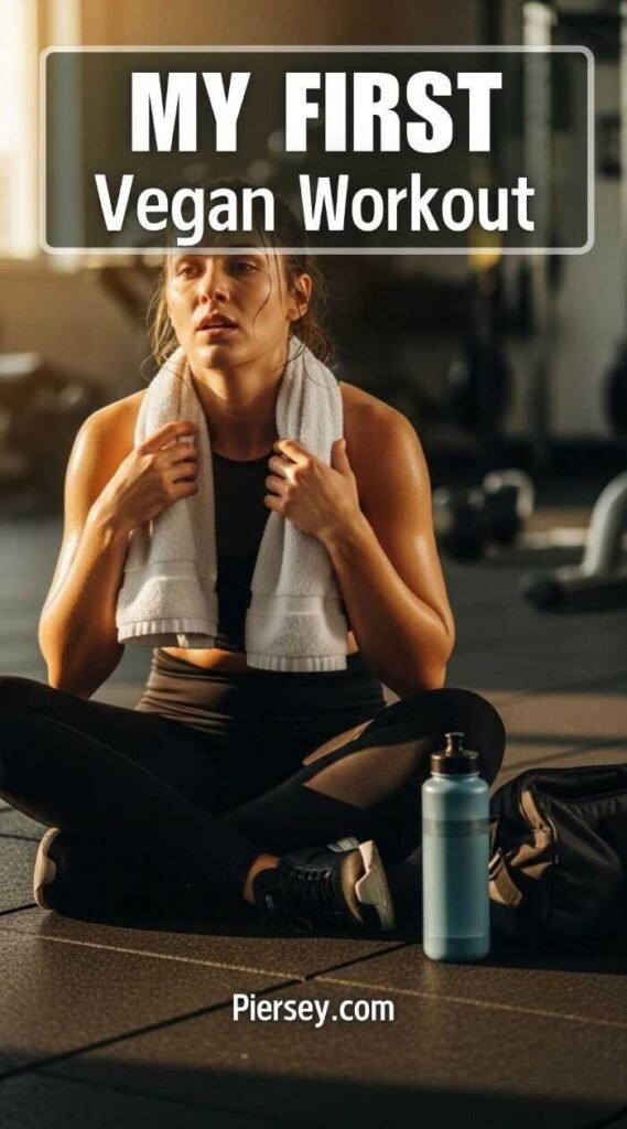 A woman sits on a gym floor with a towel around her neck, looking exhausted yet determined. Text reads "My First Vegan Workout" at the top.